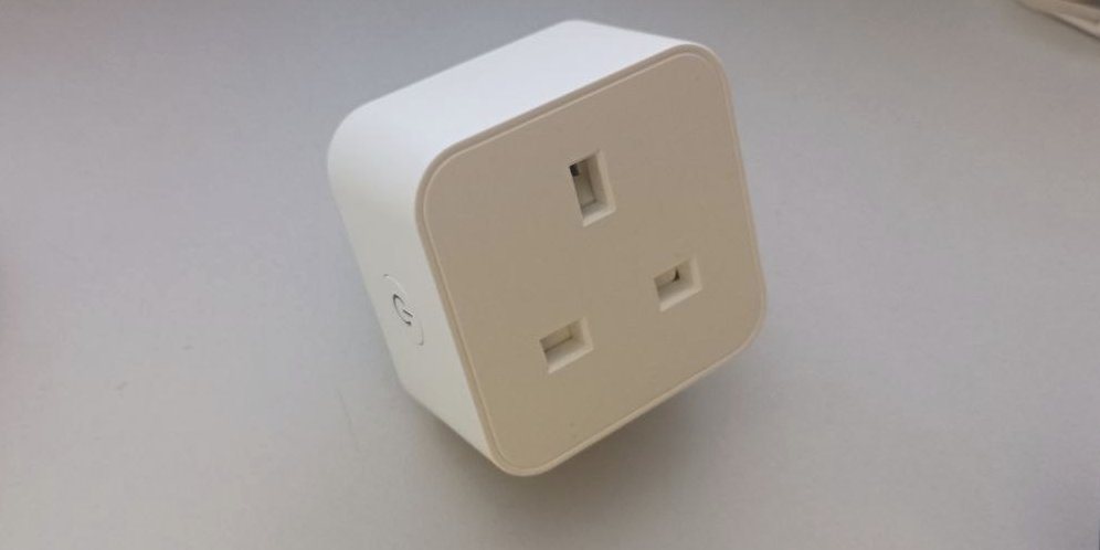 A smart plug, shown in isolation on a desk